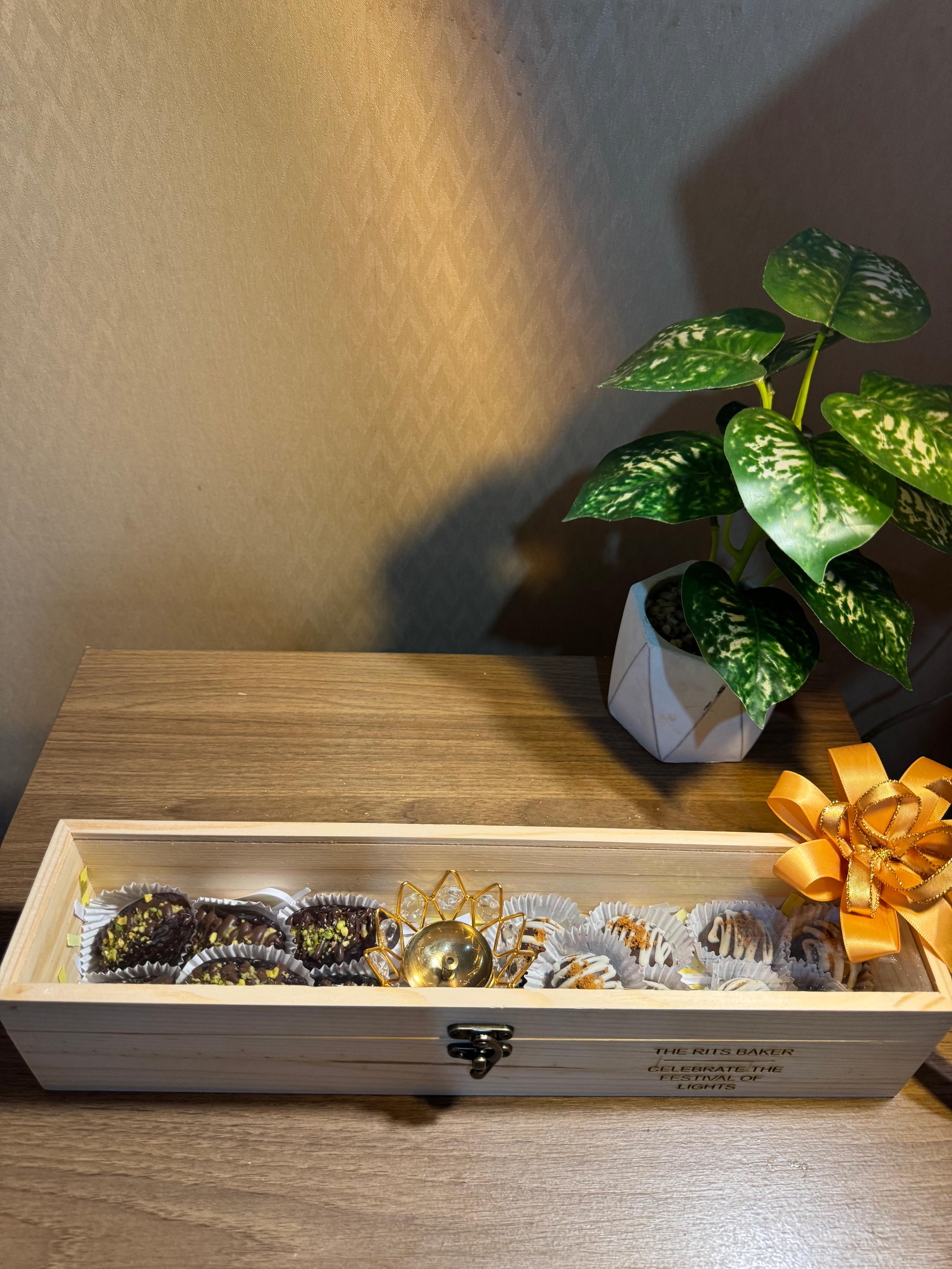 The Exclusive Diwali Gift by The Rits Baker — handcrafted wooden keepsake box with brass diya, Pistachio Medjool Dates, and Biscoff Truffles