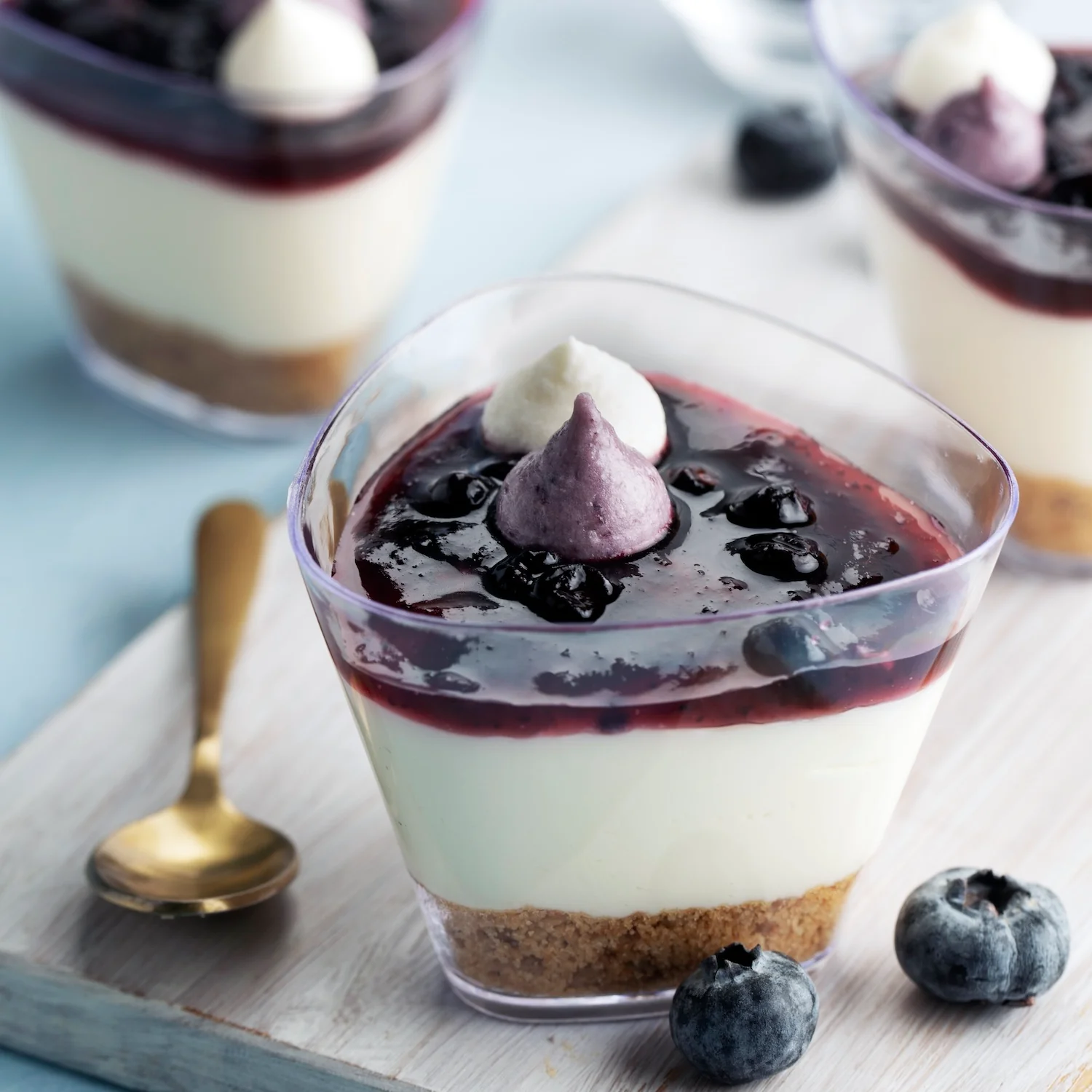 Layered blueberry cheesecake cup with fresh blueberry compote